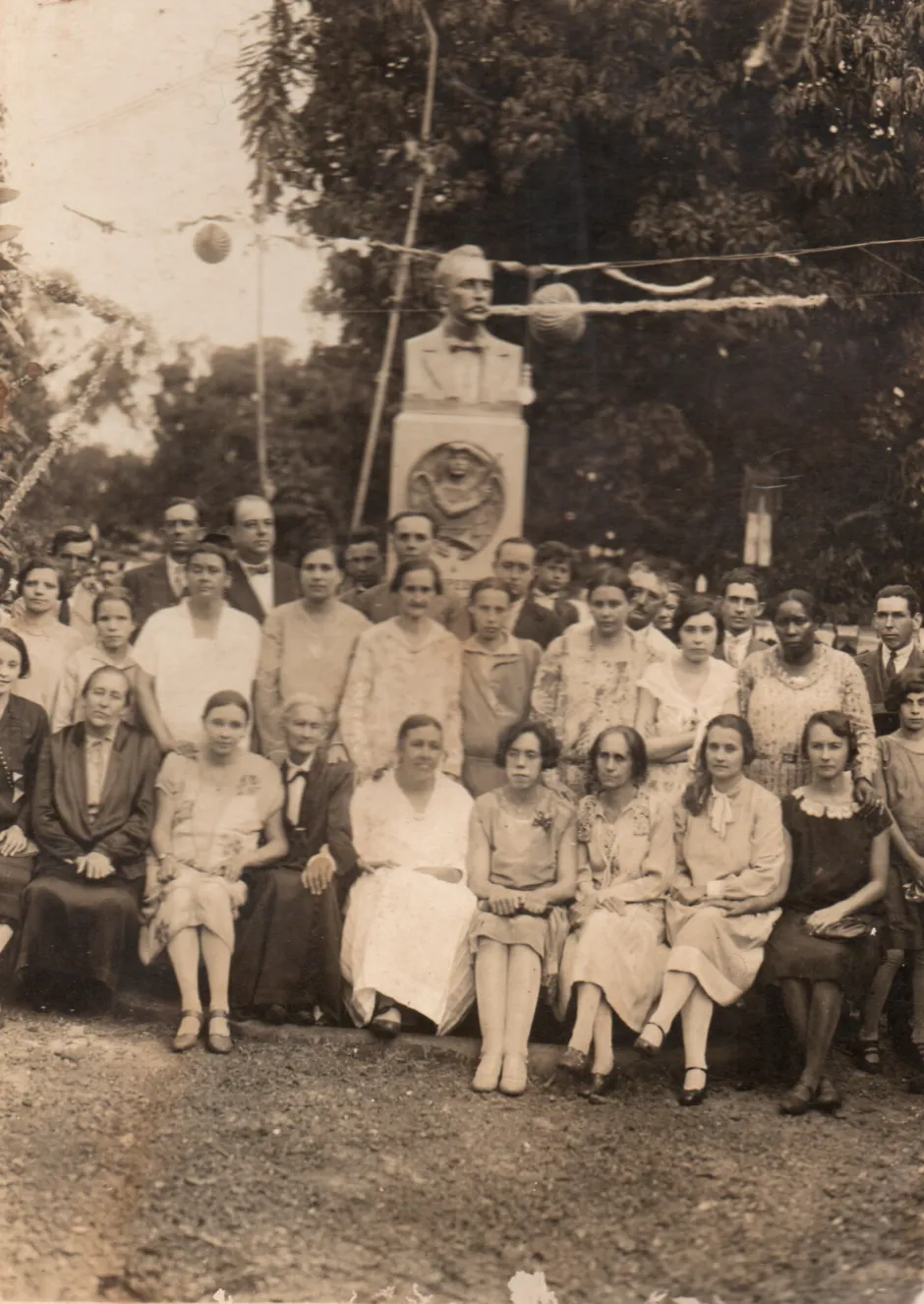 Grupo de pessoas reunido ao redor da herma de Eurípedes Barsanulfo, em fotografia antiga