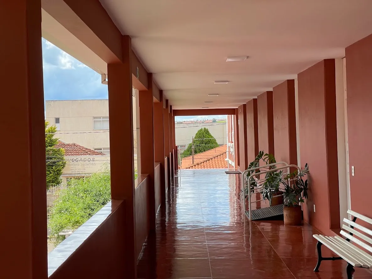 Pátio do Colégio Allan Kardec com pérgola florida diante da fachada