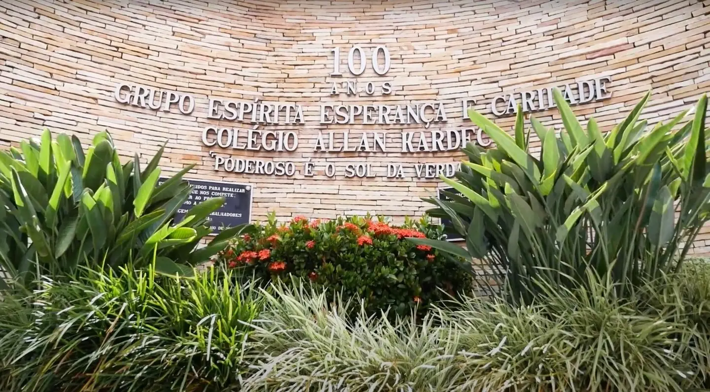Placa dos 100 anos do Grupo Espírita Esperança e Caridade, com jardim à frente
