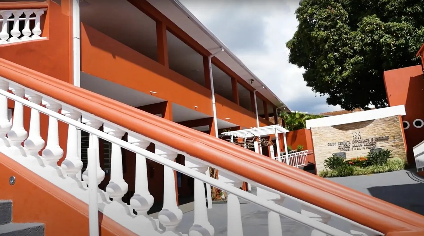 Escadaria com balaústres brancos e o pátio do Colégio